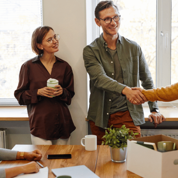 Coworkers discussing employee relocation policies in a modern office environment.
