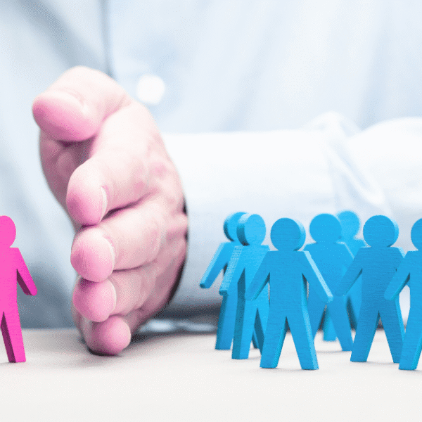 Workplace sexual orientation discrimination illustrated by a hand separating a pink figure from blue figures, highlighting isolation in the workplace.