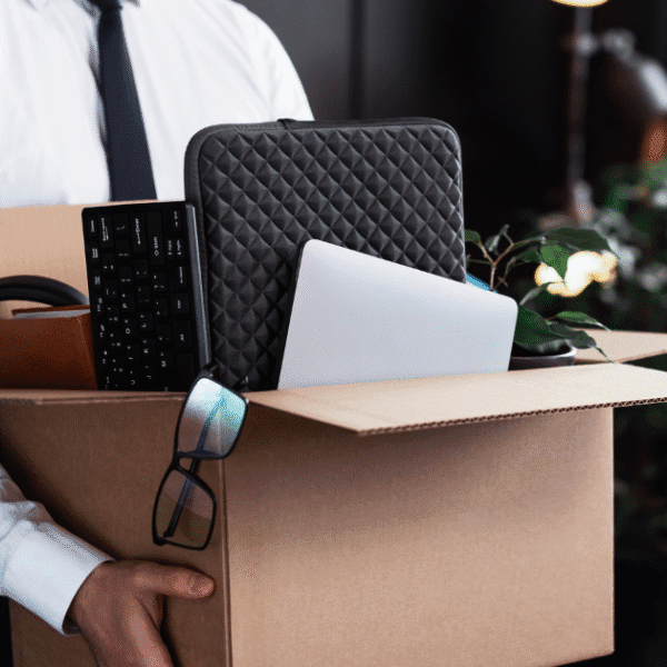 Professional carrying office belongings in box after probationary termination - documenting proper exit procedures under termination laws.