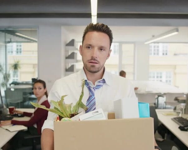 Laid-off employee leaving the office after termination and preparing to evaluate his rights under Tennessee severance laws.