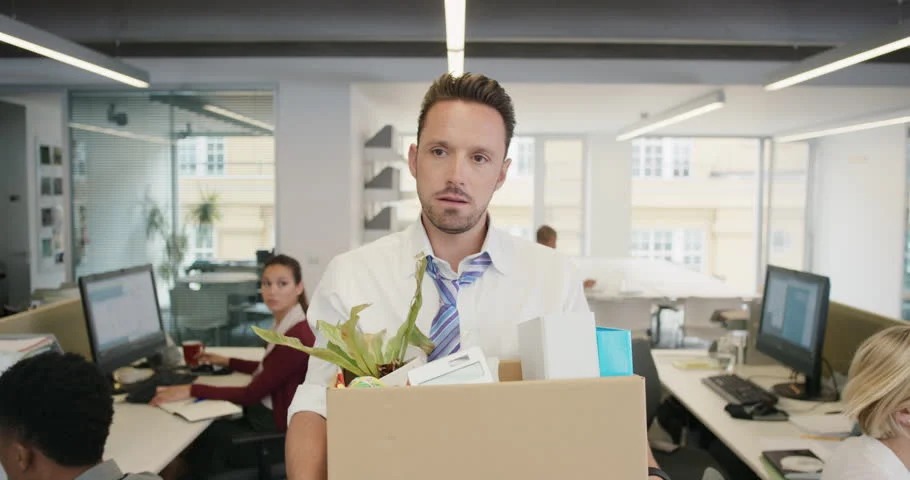 Laid-off employee leaving the office after termination and preparing to evaluate his rights under Tennessee severance laws.